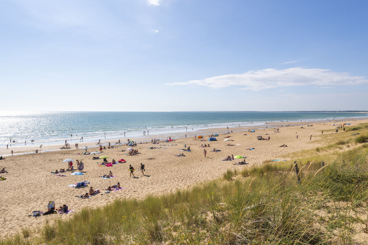 Fijn zandstrand, zwemmers en duinen bij camping CAPFUN Prises in La TRANCHE SUR MER.