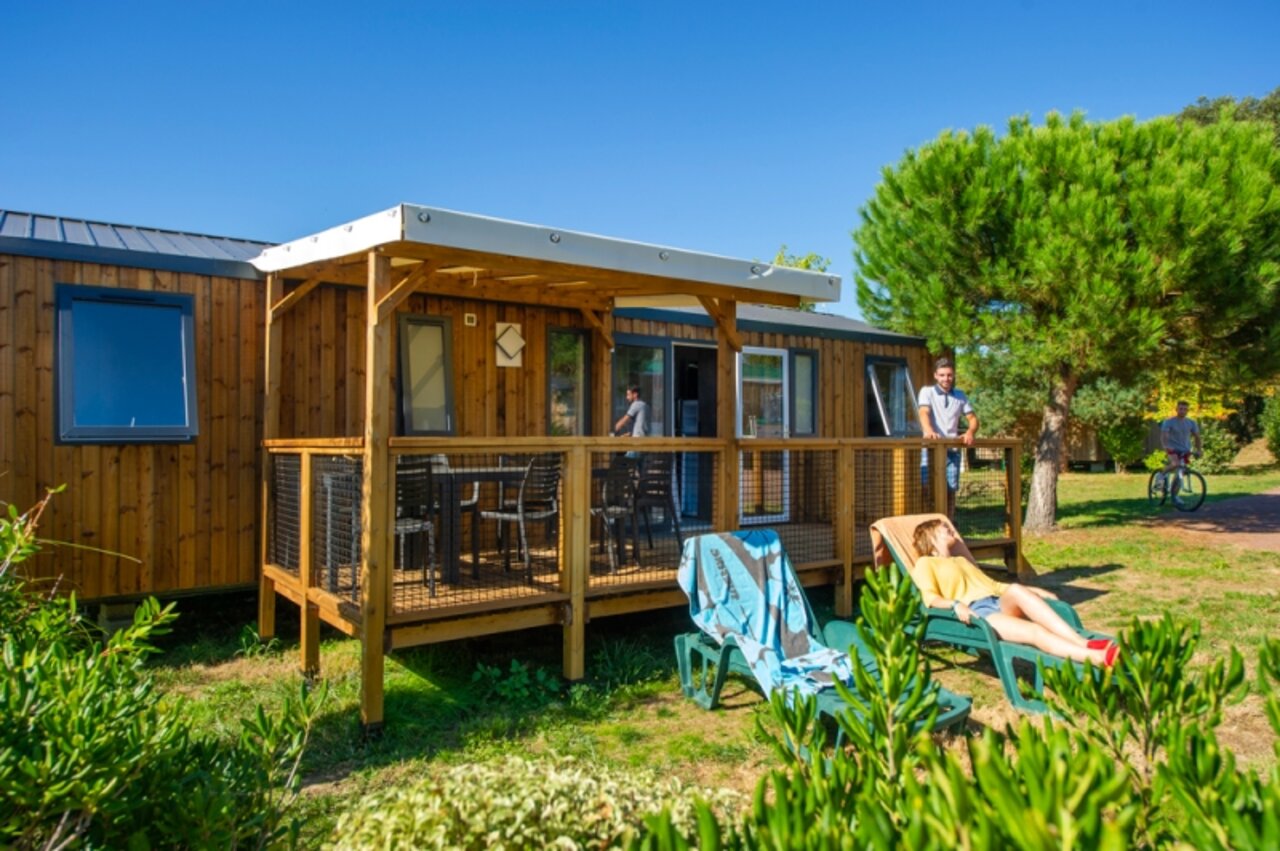 Houten Mobil-home met overdekt terras en ligstoelen op camping CAPFUN Quatre Vents d'Ol�ron in St Georges d�Ol�ron (17).