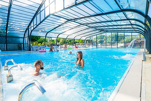 Overdekt zwembad, jacuzzi en zwemmers op camping CAPFUN Quatre Vents d'Oléron in St Georges d'Oléron (17).