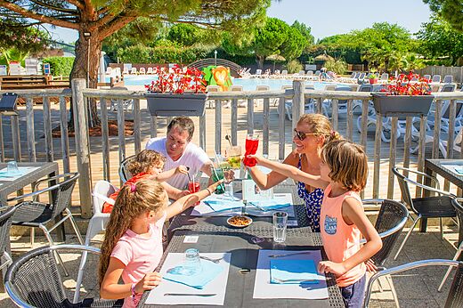 Familie proostend op terras restaurant camping CAPFUN Quatre Vents d'Ol�ron.