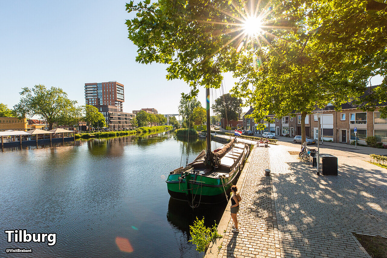 Kanaal met traditionele boot en moderne gebouwen in Tilburg, Noord-Brabant.