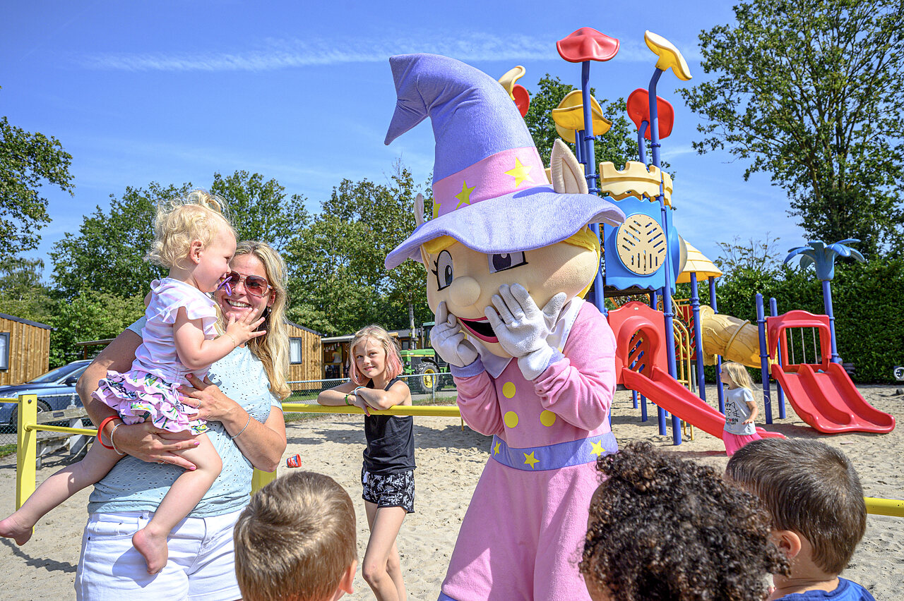 Mascotte en lachende kinderen op de speeltuin van camping CAPFUN Rakelbos in Westelbeers.