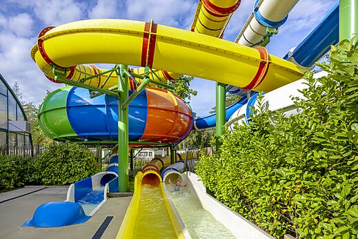 Kleurrijke waterglijbanen en buitenzwembad op camping CAPFUN Rakelbos in Westelbeers.