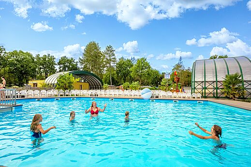 Familie plezier makend in het grote zonnige buitenzwembad op camping CAPFUN Rakelbos in Westelbeers.