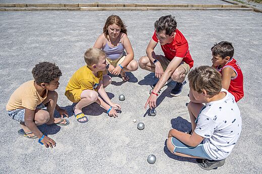 Levendig potje jeu de boules met kinderen op camping CAPFUN Rakelbos in Westelbeers.
