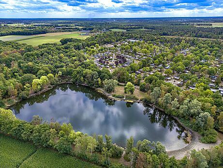 Luchtfoto van het meer, bos en stacaravans op camping CAPFUN Rakelbos in Westelbeers.