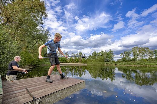 Vissen op vlonder met hengel en schepnet op camping CAPFUN Rakelbos in Westelbeers.