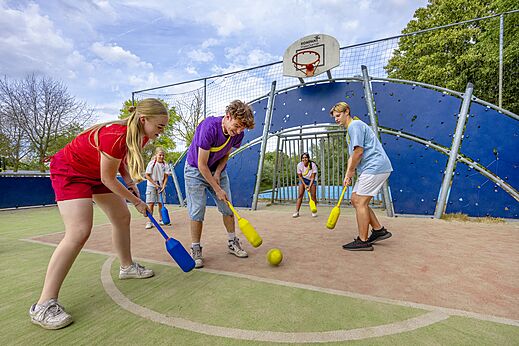 Jongeren spelen hockey op een multisportterrein op camping CAPFUN Rakelbos in Westelbeers.