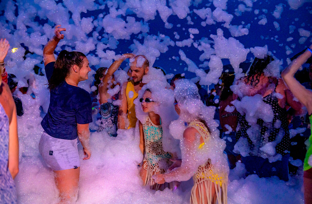 Feestelijke schuimparty sfeer met vakantiegangers op camping CAPFUN Ranch des Volcans in Chatel-Guyon.