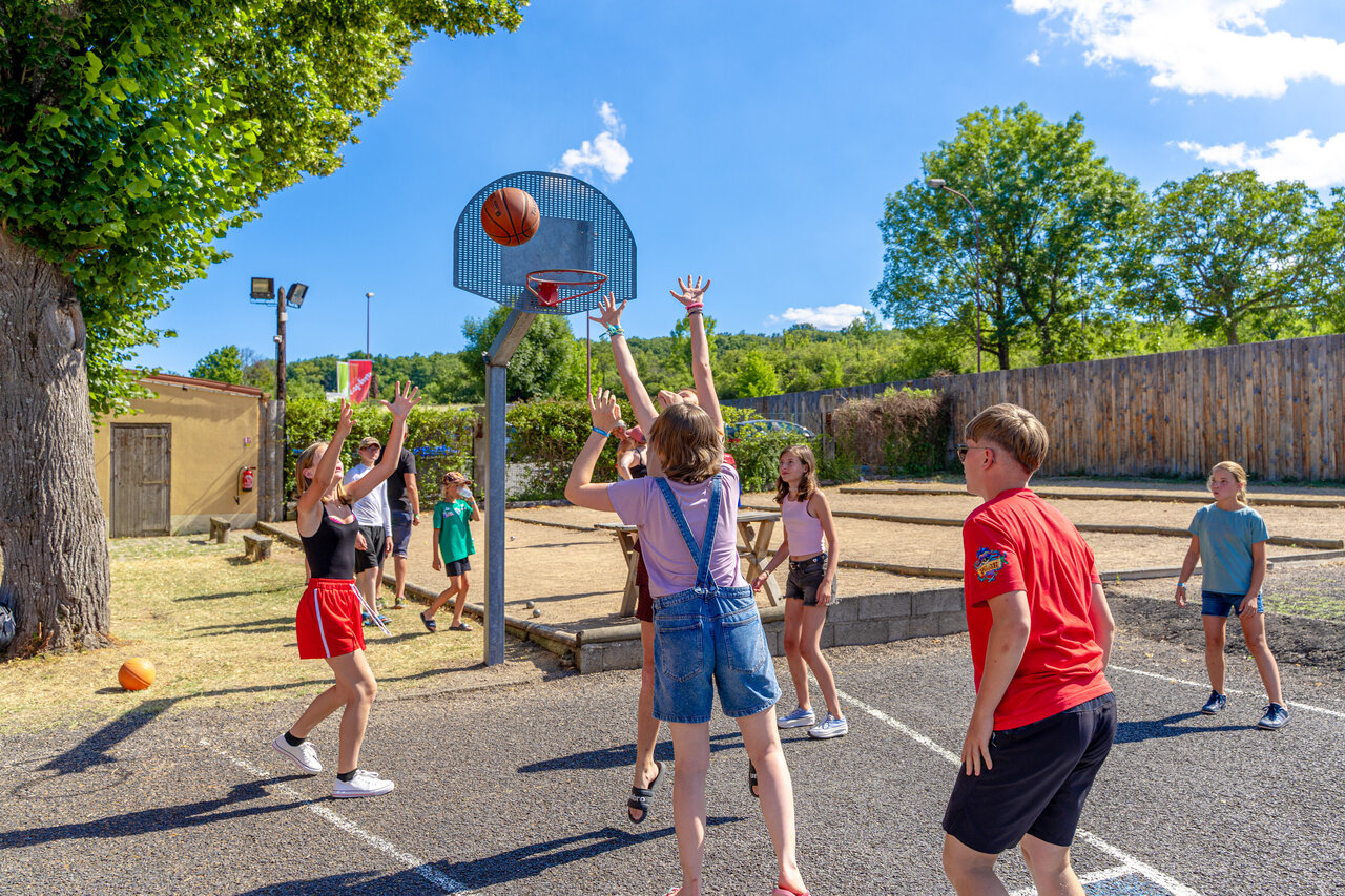 Kinderen basketballen op buitensportterrein op camping CAPFUN Ranch des Volcans in Chatel-Guyon (63).