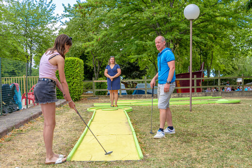 Familie speelt minigolf op een buitenbaan op camping CAPFUN Ranch des Volcans in Chatel-Guyon (63).