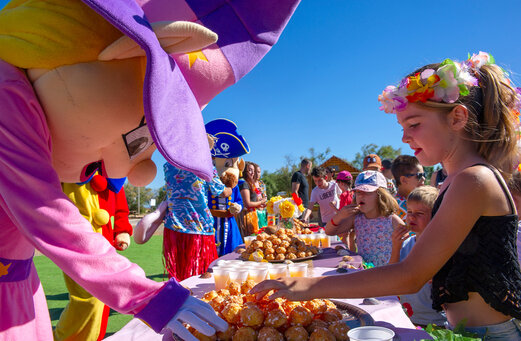 Mascottes en blije kinderen genieten van een gebaksbuffet op camping CAPFUN Ranch des Volcans.