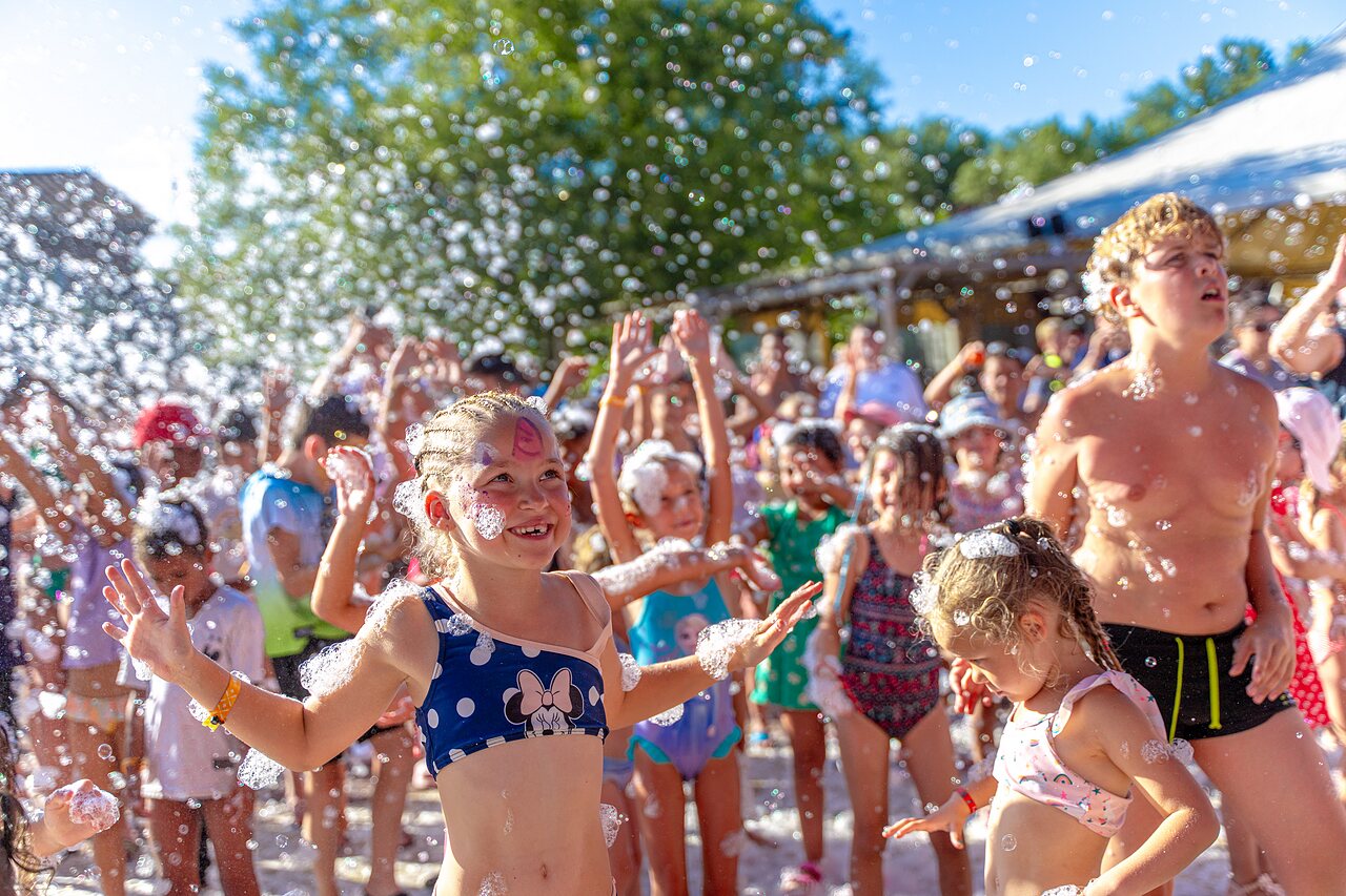 Vrolijke kinderen genieten van een schuimparty animatie op camping CAPFUN R�gni�re in VILLETTE D'ANTHON (38).