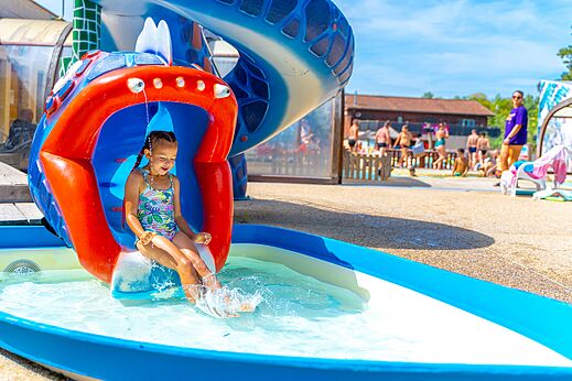Kleurrijke waterglijbaan, kind speelt op camping CAPFUN R�gni�re in VILLETTE D'ANTHON (38).