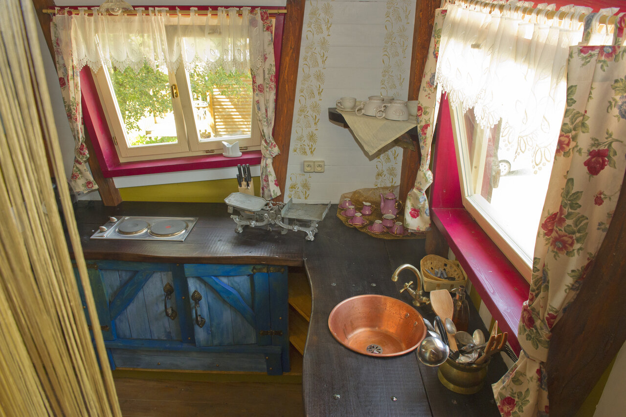 Rustieke ingerichte keuken met koperen spoelbak op camping CAPFUN R�gni�re: Boomhutten in Lyon in Villette d'Anthon (38).