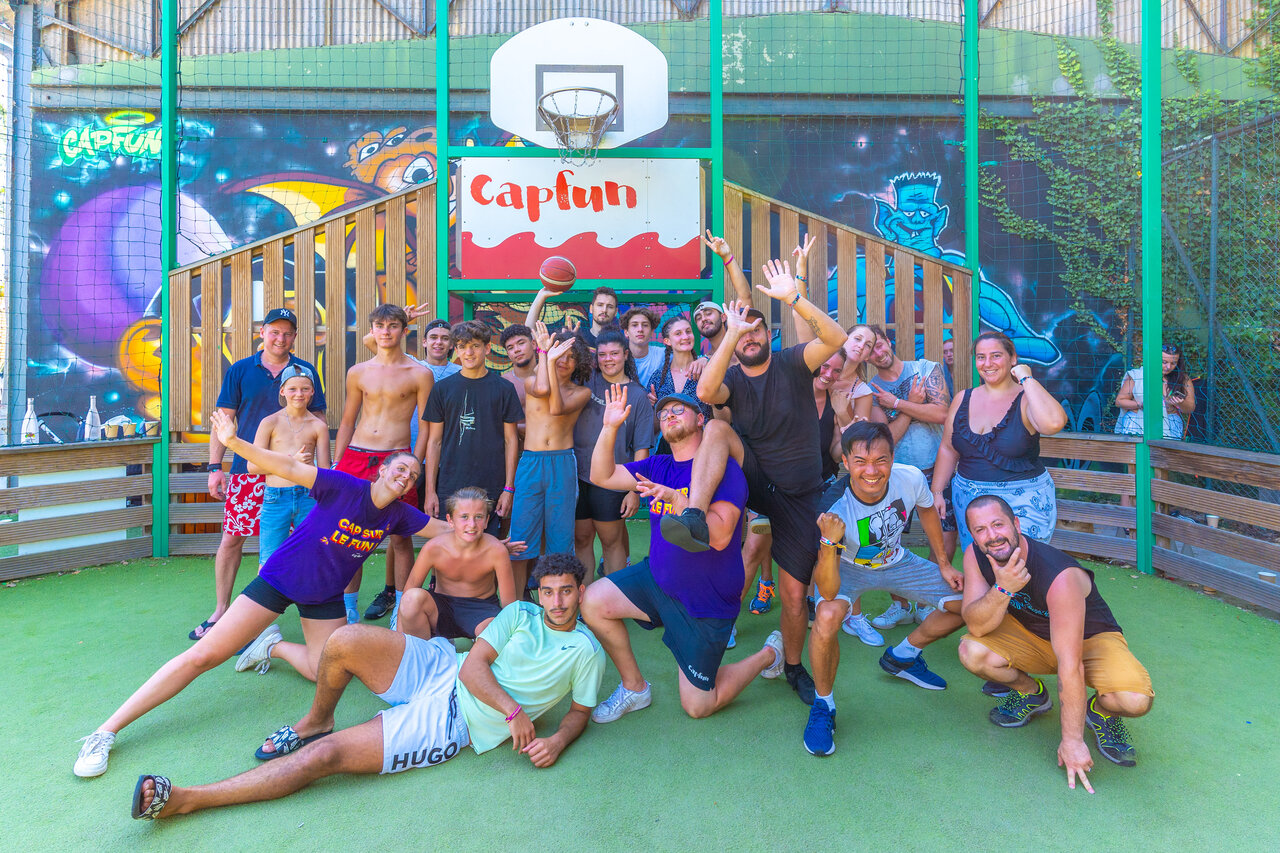 Vrolijke groep op multisportterrein met basketbalring op camping CAPFUN R�gni�re in Villette d'Anthon.