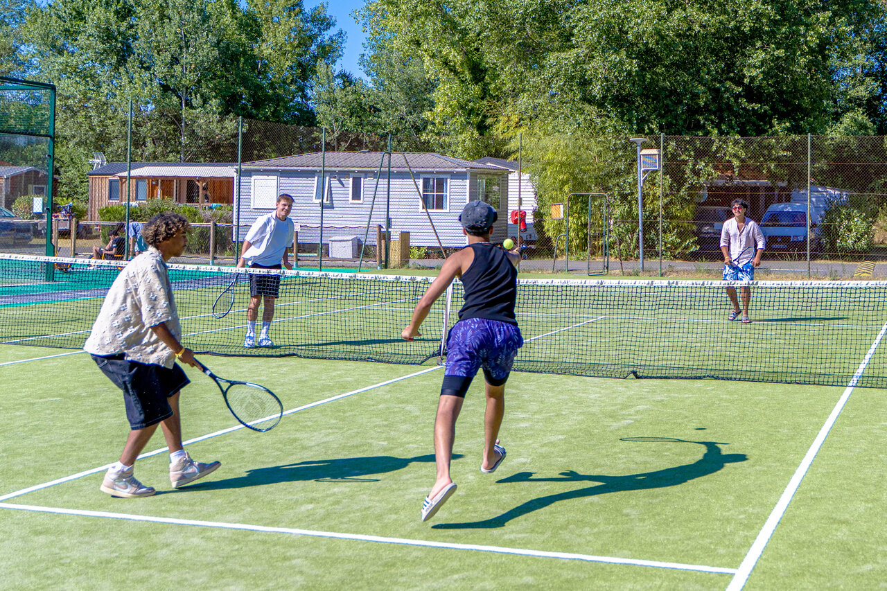 Tennisbaan met spelers, stacaravans op camping CAPFUN R�gni�re: Boomhutten in Lyon in Villette d'Anthon (38).