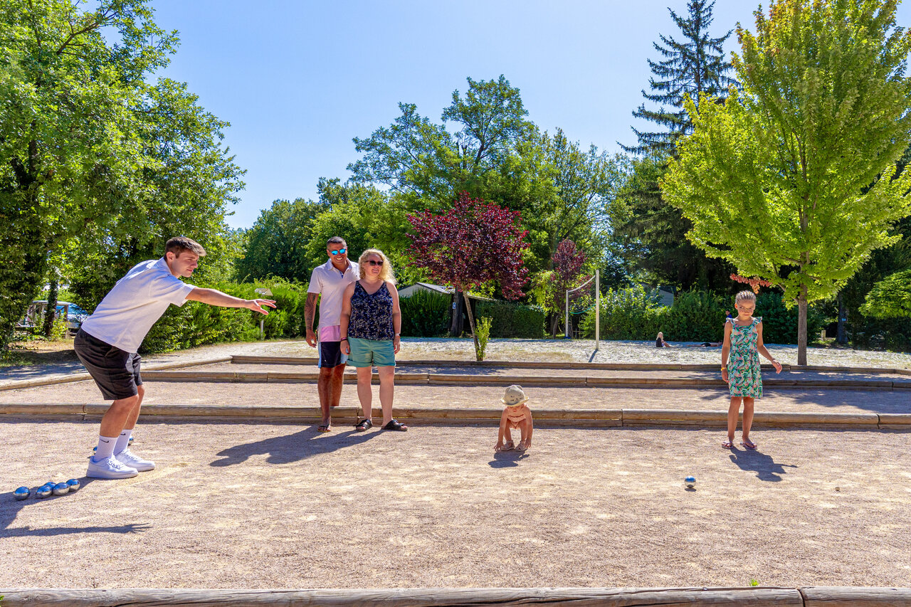 Familie speelt jeu de boules op baan op camping CAPFUN R�gni�re in Villette d'Anthon.