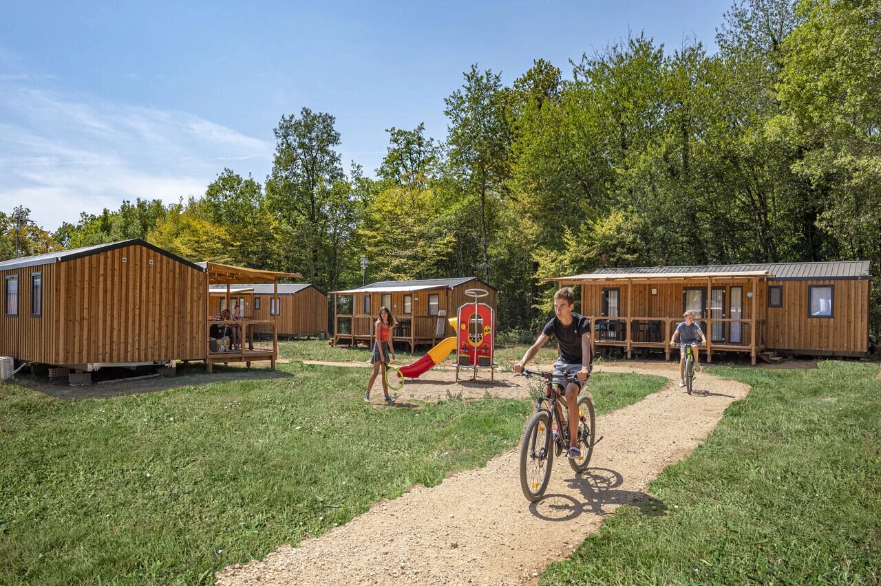 Stacaravans, speeltuin, fietsende kinderen op camping CAPFUN La Rivi�re in Valence-en-Poitou.