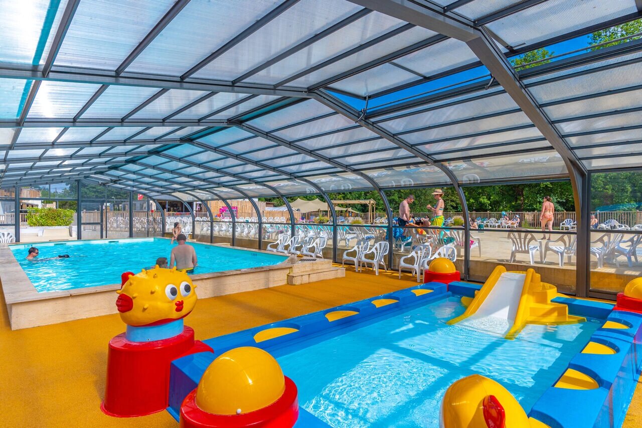 Overdekt zwembad met glijbaan en kinderbad op camping CAPFUN La Rivi�re in Valence-en-Poitou (86).