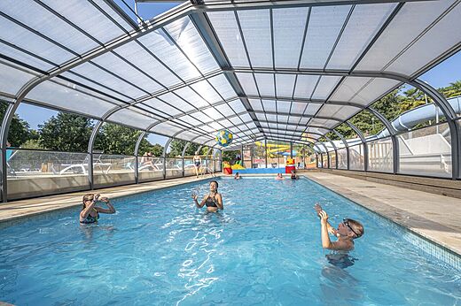 Overdekt zwembad met kinderen, glijbanen, op camping CAPFUN La Rivière in Valence-en-Poitou (86).