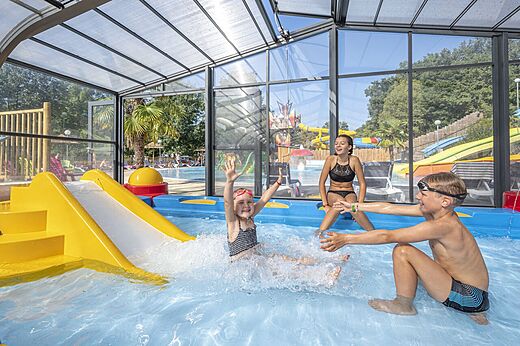 Overdekt zwembad, glijbaan, kinderen op camping CAPFUN La Rivi�re in Valence-en-Poitou (86).