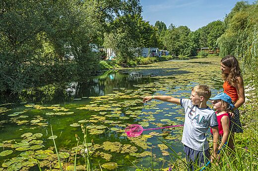Familie en kinderen vissen in rivier op camping CAPFUN La Rivière in Valence-en-Poitou.