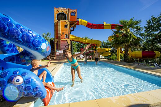 Buitenzwembad met waterglijbanen en piratenstructuur op CAPFUN Roca d'Amour.