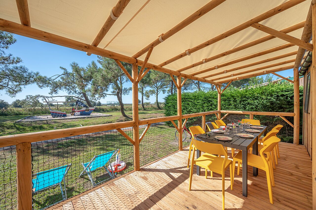 Terras stacaravan, tafel, stoelen, speeltuin op camping CAPFUN Roumingue in LANTON (33).