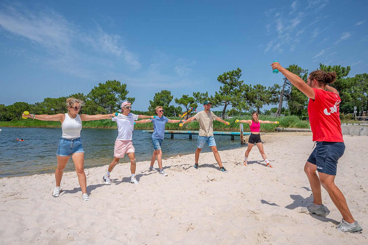 Fitness animatie op strand met gewichten op camping CAPFUN Roumingue in LANTON (33).