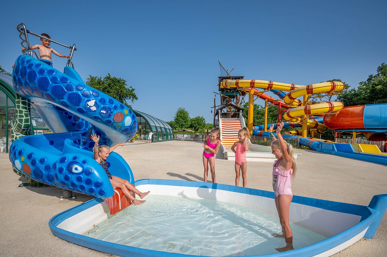 Blauwe waterglijbaan, kinderen vermaken zich op camping CAPFUN Roumingue in LANTON (33).
