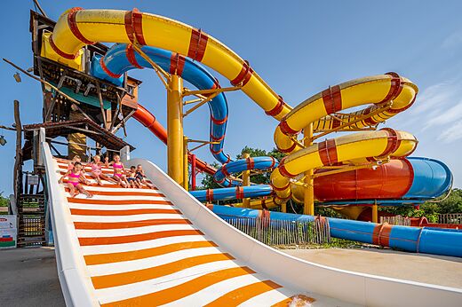 Reuzenglijbanen en spelende kinderen op camping CAPFUN Roumingue in LANTON (33).