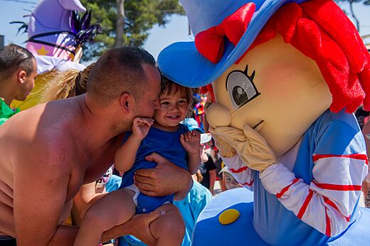 Animatie met mascotte en lachende baby op camping CAPFUN Roumingue in LANTON (33).