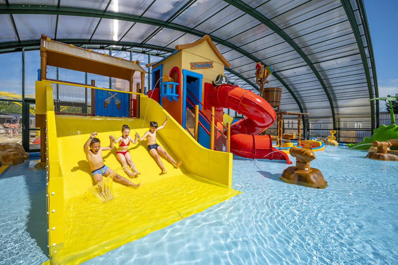 Glijbaan, overdekte waterspellen voor kinderen op camping CAPFUN La Route Blanche in Breville sur Mer (50).