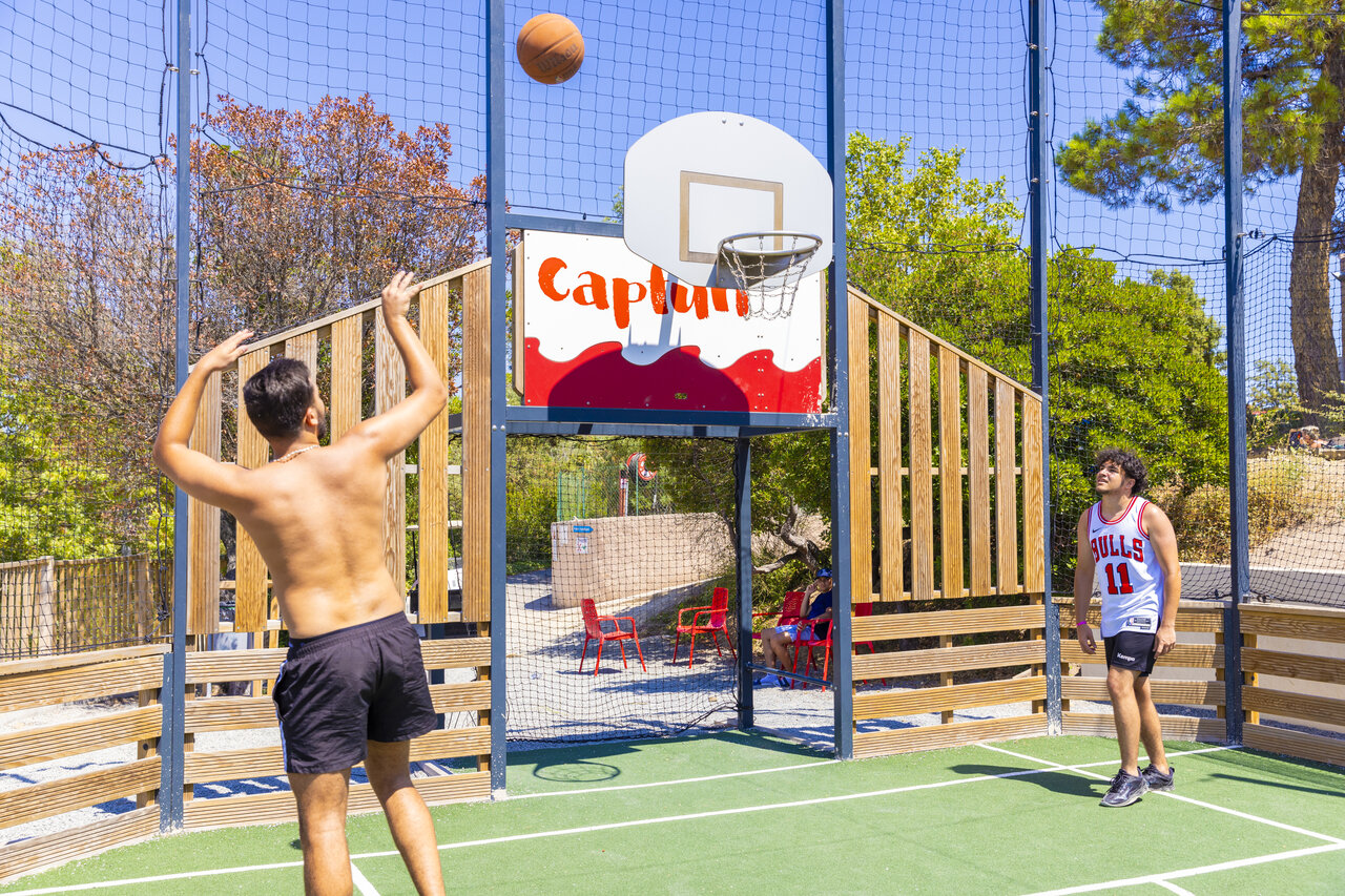 Multisportterrein met jongeren die basketballen op camping CAPFUN La Rumba in Fr�jus.