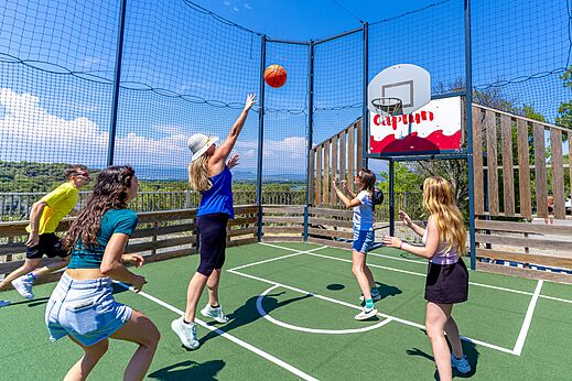 Familie speelt basketbal op het multisportterrein van camping CAPFUN La Rumba in Fréjus (83).