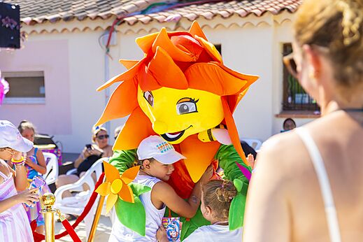 Kleurrijke mascotte interacteert met kinderen tijdens animatie op camping CAPFUN La Rumba in Fréjus (83).