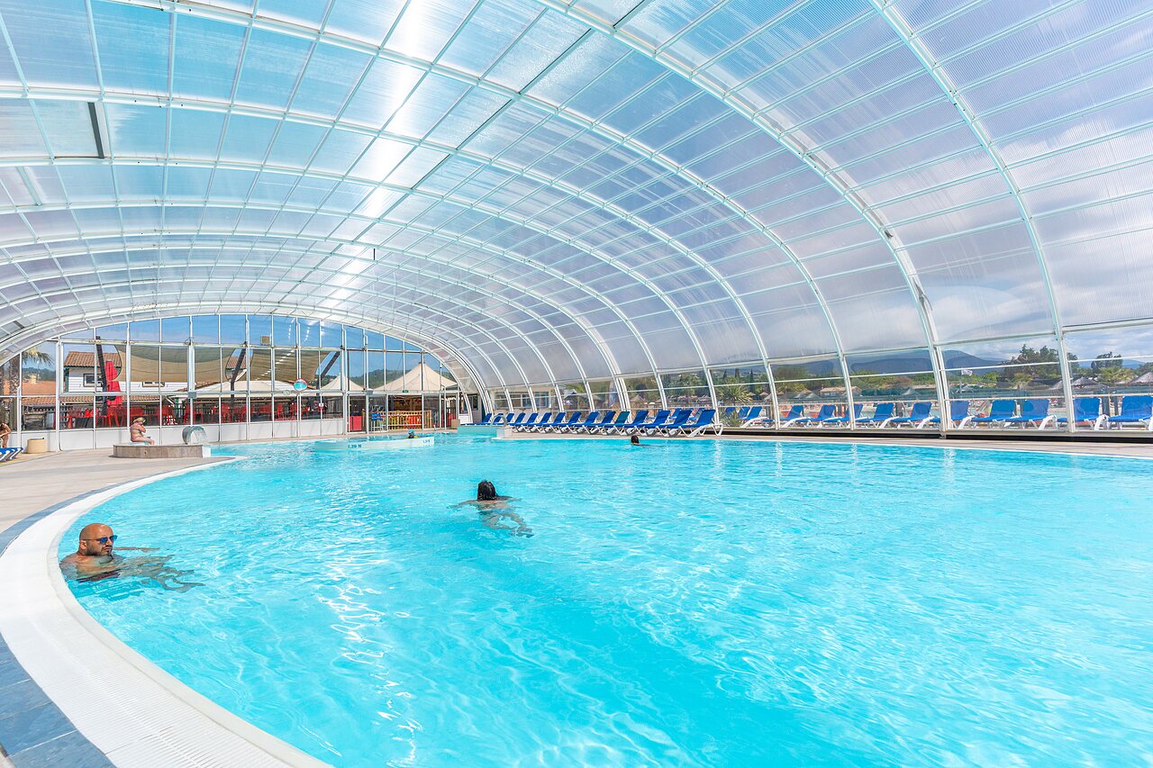 Overdekt zwembad, zwemmers en ligstoelen, camping CAPFUN Sagittaire in VINSOBRES (26).