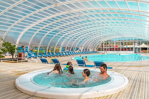 Overdekt zwembad met jacuzzi en familie op camping CAPFUN Sagittaire in VINSOBRES (26).