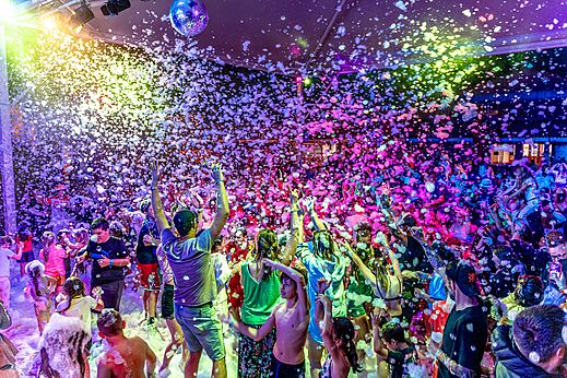 Levendig schuimfeest met kampeerders onder kleurrijke lichten op camping CAPFUN Sagittaire in VINSOBRES (26).