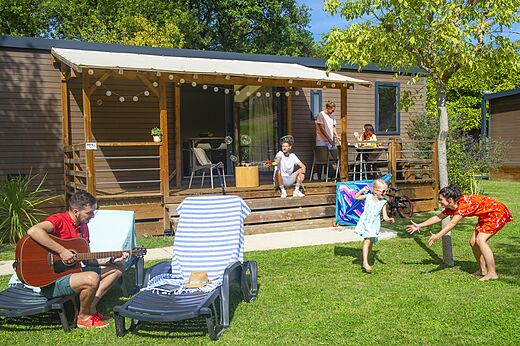 Stacaravan met overdekt terras en familie op camping CAPFUN Sagittaire in VINSOBRES (26).