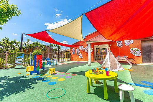 Kleurrijke buitenspeeltuin met tafels en spelletjes voor kinderen op camping CAPFUN Sagittaire in VINSOBRES (26).