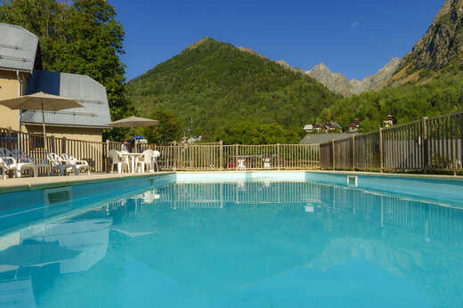 Buitenzwembad, stoelen, parasols en bergen op camping CAPFUN Saint Colomban.