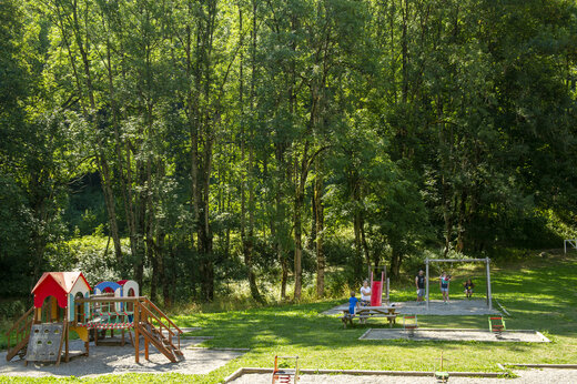 Kinderspeeltuin met speeltoestel, glijbanen en schommels op camping CAPFUN Saint Colomban.