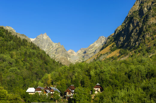 Groene bergen en traditionele huizen in alpendal, camping CAPFUN Saint Colomban.