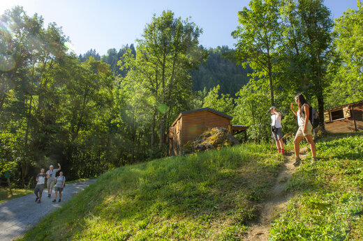 Wandelaars op bospad met stacaravans op camping CAPFUN Saint Colomban in Saint Colomban des Villards (73).