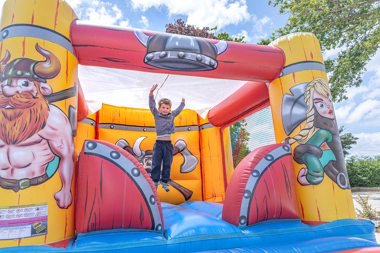 Viking springkasteel, kind springt, op camping CAPFUN Saint Laurent.