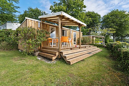 Houten Mobil-home, overdekt terras en stoelen op camping CAPFUN Saint Laurent in LA FORET FOUESNANT.