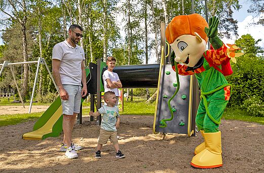 Mascotte en kinderen op de speeltuin van camping Les Saules de Cheverny.