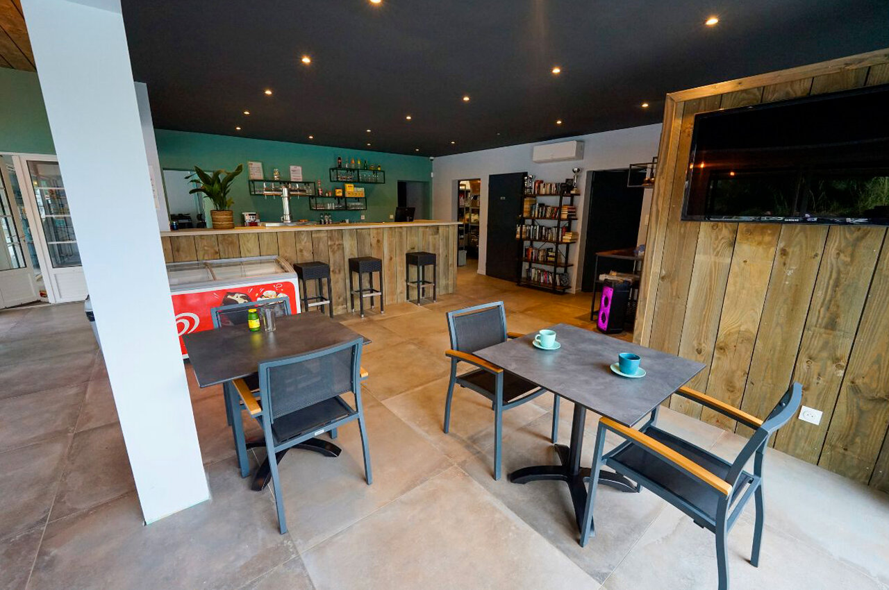 Moderne bar, tafels en stoelen, ontspanningsruimte op camping CLICOCHIC Seuli�res.